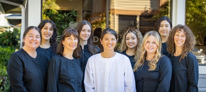 The Redmond Dental Smiles team standing together outside the office, smiling