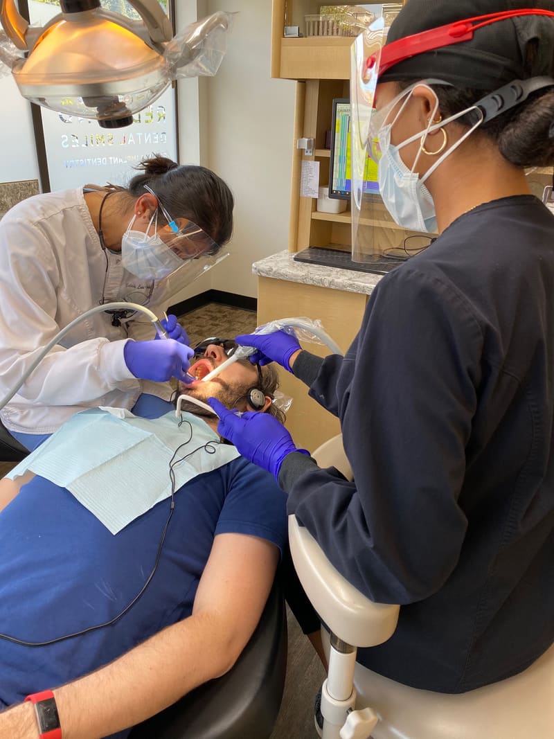 Dentist and assistant working side by side during a patient treatment