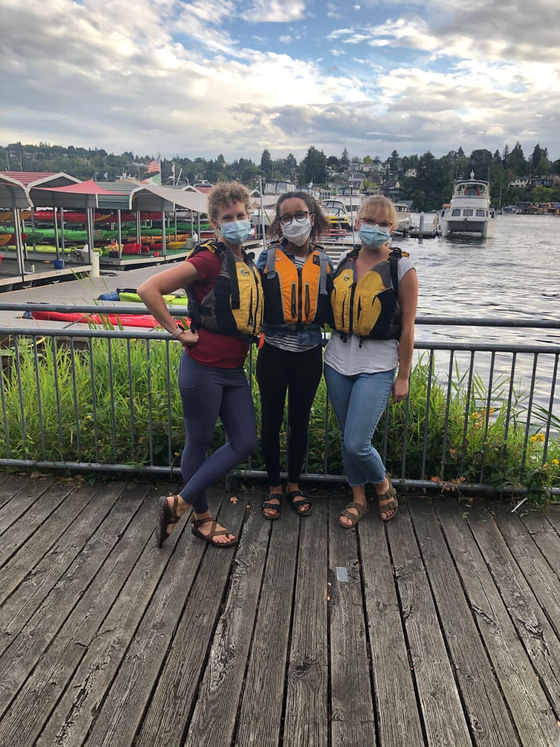 Team members in masks on a waterfront boardwalk