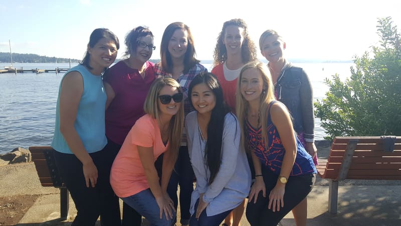 Team gathered lakeside on a sunny day