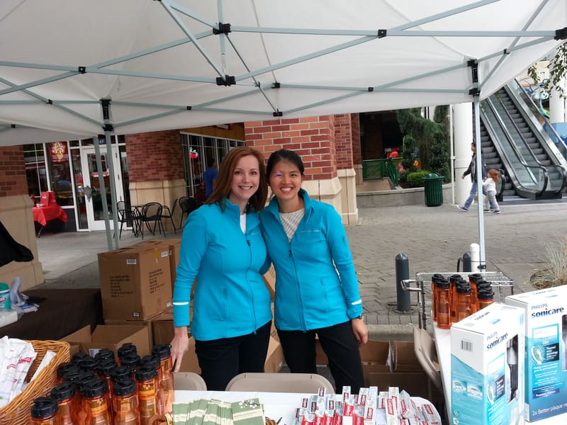 Team members at a community event tent with dental supplies