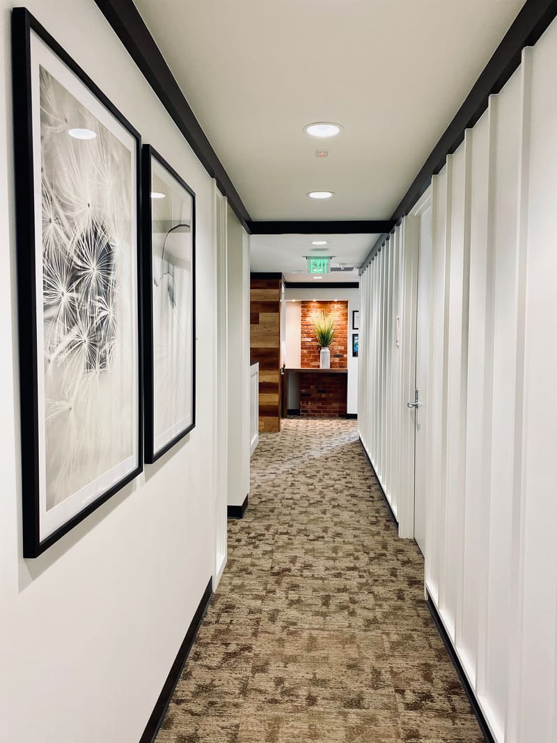 Hallway lined with framed black-and-white artwork