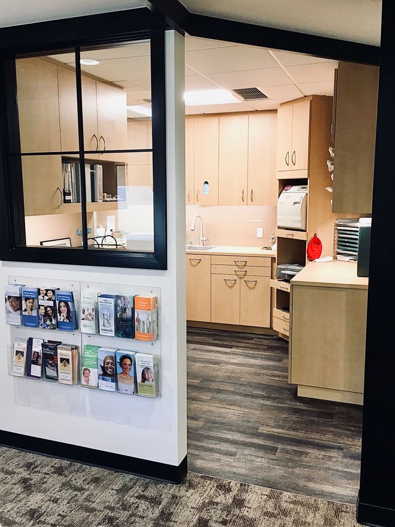 Interior window into the sterilization area with a rack of patient brochures