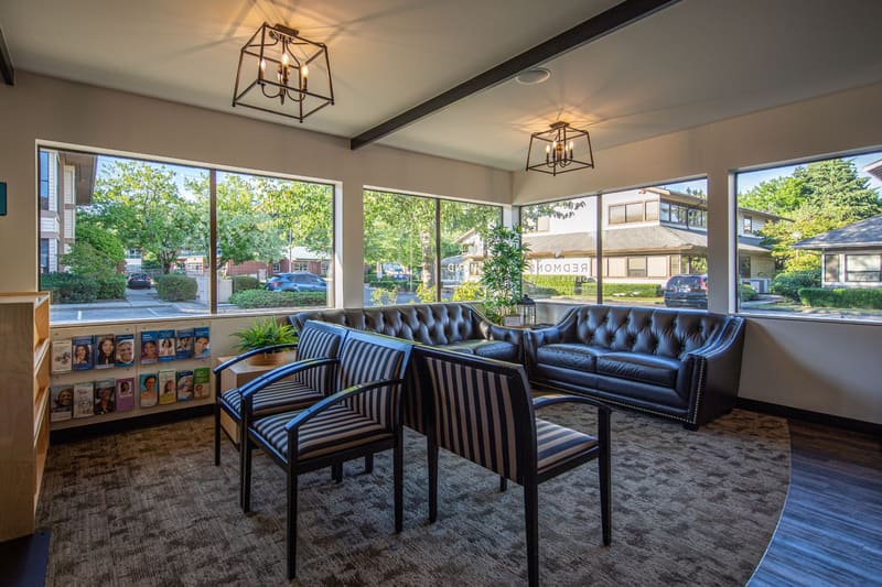 Bright waiting room with leather sofas, armchairs and large windows