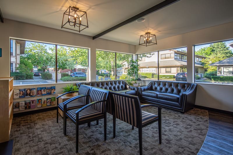 Waiting room with leather seating, a magazine rack and garden views
