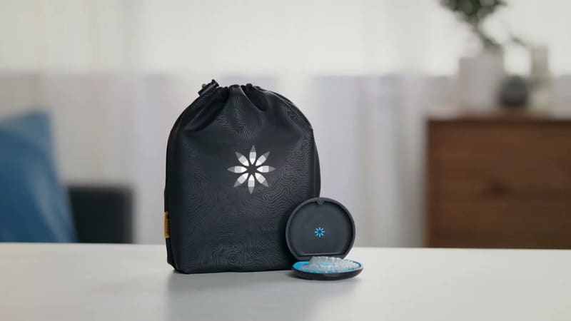 Black carrying pouch and round case for clear aligners on a white table